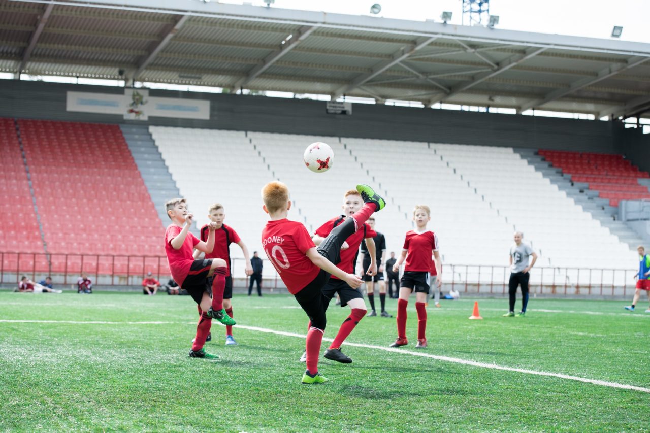 Junge Fußballspieler haben Spaß beim Spielen auf einem offenen Feld.